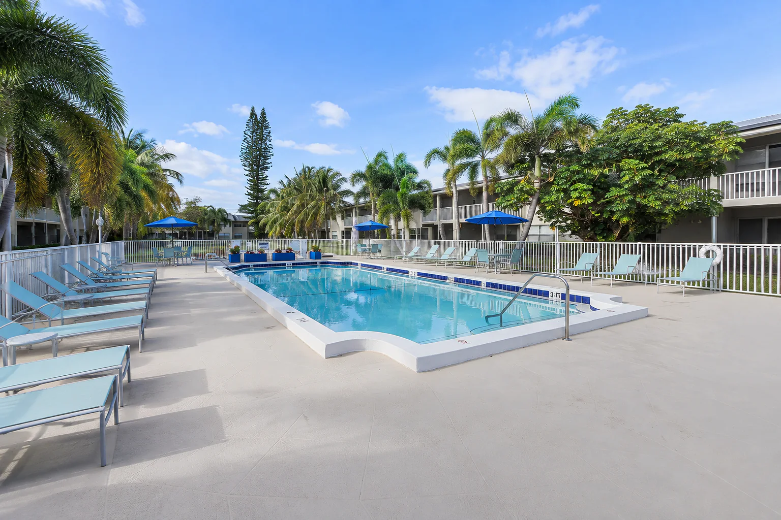 Sunny community pool surrounded by Boca Raton palms